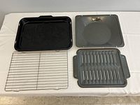 Two broiler pans laid out, showing top removable rack and bottom drip pans for both black and gray pans.