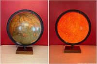 Front and illuminated view of the antique illuminated glass globe, showing geographic details and lit glow.
