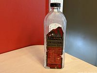 Front view of clear glass bottle showing original label with product name and partial directions.