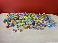Wide view showing approximately 60 colorful Grossery Gang figures arranged on a table, featuring various themed characters like rotten food and garbage items.