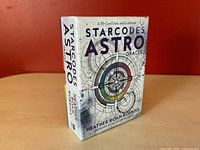 Box of the Starcodes Astro Oracle 56-card deck and guidebook showing front with title and author