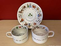 Image showing both cups and the saucer plate decorated with zodiac signs and fortune telling symbols.