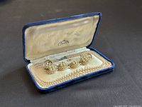 Blue velvet box open, showing bracelet, necklace and earrings inside with a cream satin interior