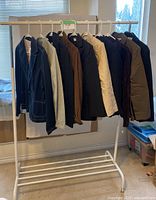 Full view of 10 women’s blazers hanging on rack, showing assorted colors and styles including denim, corduroy, and cotton blazers.