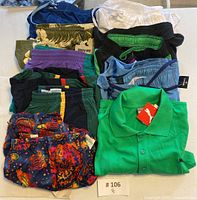 Nine pairs of men's swim trunks displayed mostly folded, beside a green Puma golf shirt.