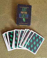 Photo of card backs and original box showing 'ART FOR THE EARTH PLAYING CARDS' text