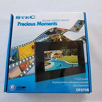 Box front of STEC Precious Moments digital photo frame showing product image, 7 inch LCD display, model DF070B, display photos without computer.