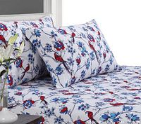 Duvet cover and two pillow shams set up on bed showing bird and floral pattern in red, blue and white.