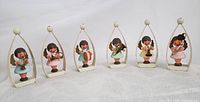 Full set of six wooden angel musicians with instruments in curved white metal frames on table