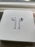 White box with image of Apple AirPods on the cover, showing original retail packaging of AirPods.