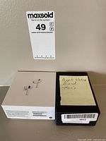 Shows Apple AirPods box and black box labeled Apple Watch Band - Men's