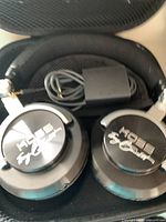 Close-up of Koss over-ear headphones inside a black zippered carrying case with coiled cable visible.