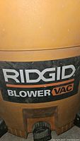 Close up of Ridgid Blower Vac label on tan vacuum body.