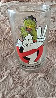 Front side of the glass showing Ghostbusters II logo with the white ghost character holding up two fingers.