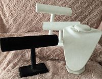 Three jewelry displays: white necklace bust and white and black horizontal T-bars