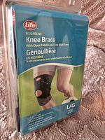 Front packaging of LIFE Neoprene Knee Brace in large size showing knee brace on leg and product features.