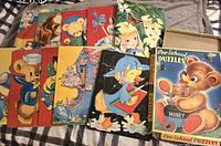 Photo showing all ten cardboard puzzles and colorful box with teddy bear illustration