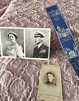 Christmas card showing portraits of King George VI and Queen Elizabeth alongside vintage tin type photo and blue leather bookmark on pink textured fabric.
