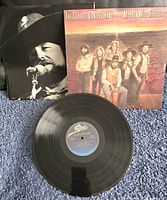 Vinyl record and album cover along with inner sleeve showing the band photos.