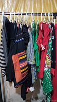 Photo of various colorful Christmas sweaters and tops on hangers with various patterns and colors