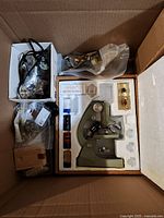 Wide view of box contents showing microscope, various hardware items, small motors and packaging