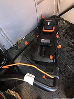 Overview of mower from front-left angle showing handle, deck and wheels