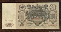 Front of 1910 Russian 100 roubles paper banknote showing denomination, ornate details, serial number, and year.