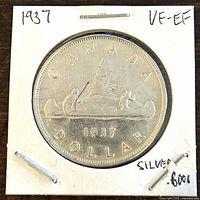 Reverse of 1937 Canadian Silver One Dollar Coin showing canoe with two figures, date 1937, and coin inscriptions.