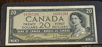Front side of 1954 Canadian $20 banknote showing Queen Elizabeth II portrait and serial number.