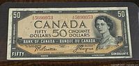 Front view of the 1954 Canadian 50 Dollar banknote showing the portrait of Queen Elizabeth II, serial number, and signatures.