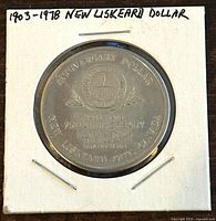 Front side of the 1978 New Liskeard Ontario 75th Anniversary trade dollar coin with detailed engraved text and emblem.