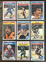 Front view of nine NHL player trading cards showing players from Nordiques, Jets, Canucks, Oilers, Bruins, and Capitals in colorful team-themed designs.