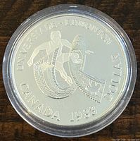 Obverse side of the 1983 Canadian silver proof coin showing Universiade Edmonton design and inscriptions.