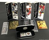 Three McDonald's NHL Star hockey sticks displayed upright with clear player images and signatures, plus two hockey cards and a golden token card, all arranged on a white surface.