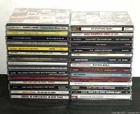 Stack of 30 assorted rock music CDs showing full spines of both stacks.