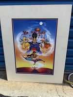 Photo of the Disney Aladdin lithograph print with visible characters including Jafar, Aladdin on magic carpet, Genie, Abu, and palace in background. The lithograph is mounted on a white matte.