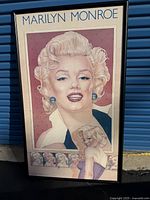 Full view of the framed Marilyn Monroe poster with multiple artistic renderings on it.