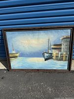Framed oil painting showing boats on a lake with a dock and buildings in soft colors