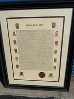 Full view of framed Magna Carta 1215 Latin papyrus with decorative crests and wax seal