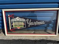 Full front view of rectangular framed pennant flag featuring New York Yankees 1960 championship team photo and text.