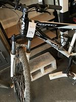 Front and partial side view of Aspect Scott bicycle frame with suspension forks and knobby tires.