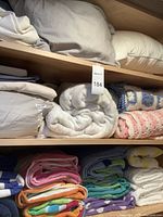 Shelves with pillows, folded sheets, blankets, and stacked beach towels