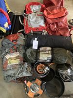 Overview of all camping gear items laid out together including backpacks, tents, and cookware.