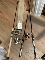 Three rods laid on floor with two spinning reels placed in front