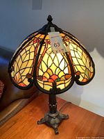 Full view of the Kichler Tiffany style stained glass table lamp illuminated showing the colorful mosaic pattern and scalloped shade edge.