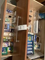 Drawer organizer with assorted personal care products and hygiene items, showing bottles, band-aids, soap bars, and containers