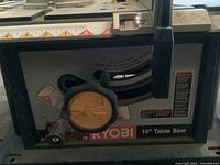 Close-up of Ryobi table saw adjustment controls and branding