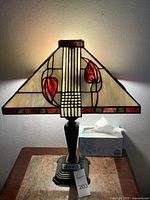 Front view of lit lamp showing shade design and base.