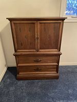 Front view of traditional wooden dresser with carved doors and two drawers below