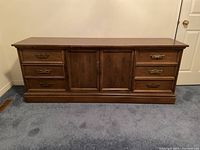 Front view of traditional wooden sideboard with six drawers and cabinet doors.